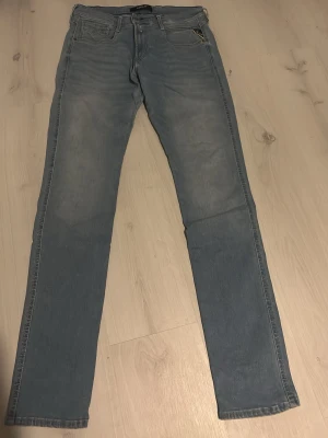 Replay Hyperflex ljusblå jeans - Säljer ett par Replay Hyperflex jeans i ljusblå tvätt med klassisk femficksdesign och snygga detaljer. Jeansen har en slim passform och är tillverkade i stretchigt jeansmaterial som ger extra komfort. Perfekt för dig som gillar stilrena och bekväma jeans. För mer bilder är det bara att skriva😊