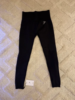 Gymshark Träningstights – Svart  - Gymshark Träningstights – Svart  👖 Storlek: S ✨ Skick: 10/10 – helt nya, aldrig använda 🏷️ Detalj: Med originaltag kvar 💎 Märke: Gymshark