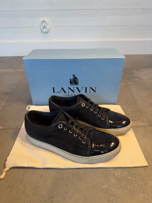 Svarta Lanvin skor - Säljer mina svarta Lanvin skor med glansig captoe. Skorna är i storlek 43 och är i ett mycket bra skick, 8/10. Nypris är ca 4500 kr. Box och dustbag ingår, samt skosnören (gamla). Skriv för fler bilder eller ifall du har några generella frågor! Inga frågor är dumma. 😊👍