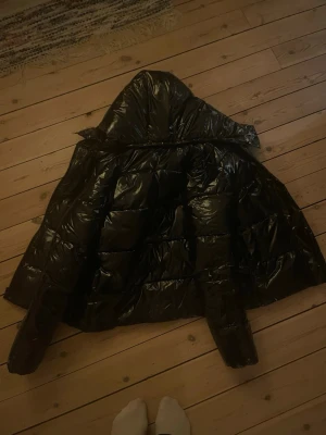 Svart glansig jacka från Calvin Klein - Svart glansig ”puffig” jacka använd då tals gg storlek s säljs då jag köpt en ny jacka istället. Inga märken eller något som ny.