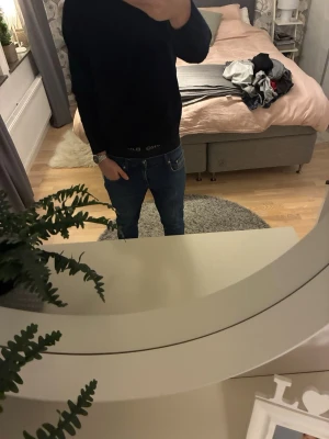 East west jeans  - Säljer ett par klassiska blå jeans med straight fit och normal passform. Jeansen har fem fickor, knapp och dragkedja framtill samt snygga slitningar för en cool look. Materialet är robust denim i bomull och färgen är mörkblå med lätt tvättade detaljer.