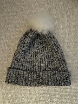 RIVER ISLAND MÖSSA - En grå stickad mössa med vit fluffig boll på toppen från River Island.