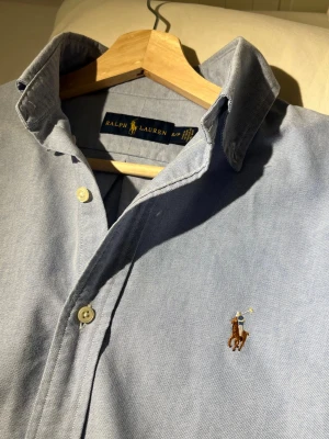 Ljusblå skjorta från Ralph Lauren - Snygg ljusblå skjorta från Ralph Lauren med klassisk krage och broderad logga på bröstet. Inga defekter. Skriv gärna om du har frågor🙌