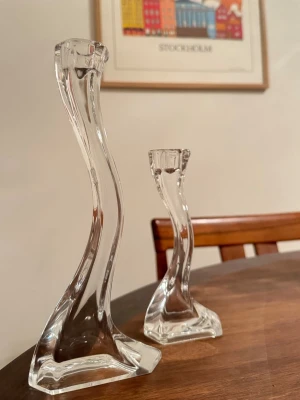 Ljusstakar - Två transparenta, böjda ljusstakar i glas. Helt nya i kartong! 
