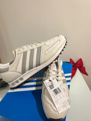 Adidas LA Trainer - Adidas LA Trainer OG sneakers i vitt och ljusgrått skinn. Helt nya med tags och kvitto. Kan mötas upp i Stockholm och tveka inte att höra av dig!