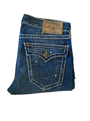 True Religion Jeans Ricky Super T - True Religion Jeans, Ricky Super T, storlek 34, väldigt bra skick, sällsynt, midja 46cm, längd 113cm, innerben 84cm och 23.5cm ben öppning. Skriv om ni undrar någonting 📲