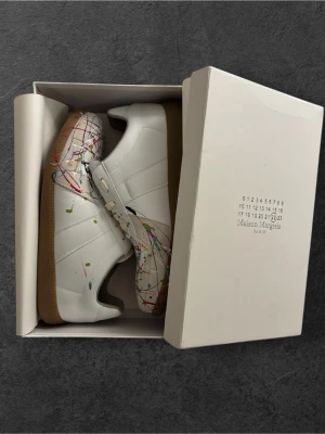 Maison Margiela sneakers med färgstänk - Maison Margiela Paint splatter gats, strl 45 men passar även 44. Köpta begagnade men i princip oanvända! Priset går att diskutera