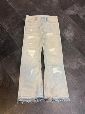 MARES TAKEOVER 1 OF 1 ”CLOUD” - Säljer ett par ljusblå jeans med flera slitningar och hål på benen för en riktigt edgy look. Jeansen har rak passform och rå, fransig kant längst ner. Perfekta för dig som gillar en avslappnad och trendig stil.