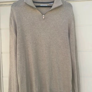 Beige half zip tröja Jack & Jones - Snygg beige tröja från Jack & Jones med half zip-dragkedja i halsen. Klassisk och enkel design med lång ärm och ribbade muddar. Perfekt till lager på lager och funkar året runt. Tillverkad i mjukt material för skön känsla.