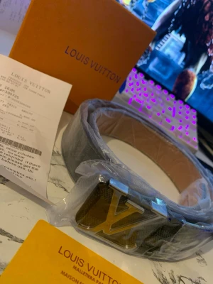 L,V monogram bälte svart/silver - Säljer ett L,V bälte i klassiskt svart monogrammönster med en stor L,V-logga i silver på spännet. Bältet är gjort i läder och har exklusiv känsla. Kommer med originalbox och certifikat.