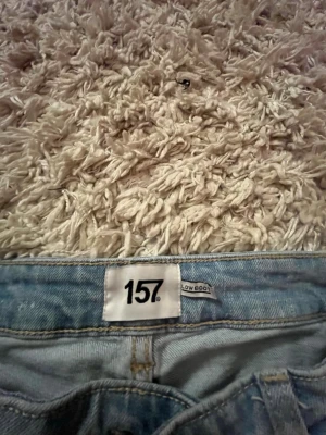 Ljusblå low bootcut jeans från 157 - Säljer ett par ljusblå jeans från 157 med klassisk femficksdesign och low bootcut. Jeansen är sååå sköna att ha på sig och är tillverkade i ett mjukt denimtyg som passar perfekt till en avslappnad stil. Snygga att matcha med sneakers eller boots. !!storleken är jag inte säker med så jag tog 30 men om jag har fel så vet ni varför men dem passar perfekt för mig som är 160 cm!!