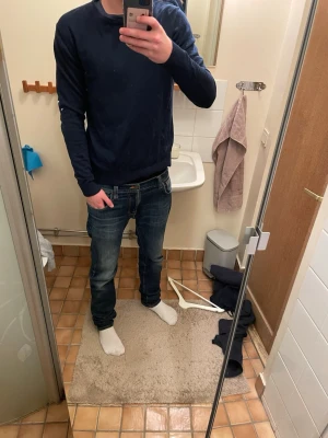 Mörkblå tröja från Jack & Jones - En stilren mörkblå tröja från Jack & Jones med rund halsringning och långa ärmar. Perfekt basplagg som funkar till det mesta och är lätt att matcha med jeans eller chinos. Tillverkad i mjukt material för skön känsla hela dagen.