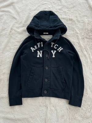 Abercrombie & fitch hoodie  - En hoodie från Abercrombie & fitch i storlek M ”muscle” (HERR). Kan upplevas mindre i storlek, likt en S. Finns 1 litet hål vid armhålan men går lätt att sy ihop. Jag fraktar inom 24h, frakt med PostNord prioriteras. Se liknande plagg i min profil!