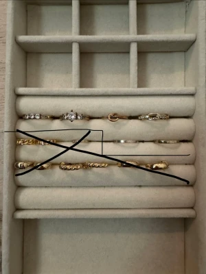 Guldfärgade ringar med stenar - Flera tunna ringar i guldfärg, vissa med gnistrande stenar och detaljerade mönster. Några ringar har tvinnad design och andra är släta. Perfekta för att mixa och matcha för en personlig stil. De är köpta på Ur och Penn, deras kollektion i rostfritt stål som är guldpläterade❤️‍🔥Storlek runt 17. 15kr styck eller alla för 60kr🙏🏼