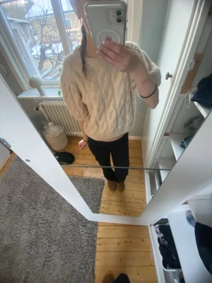 Beige kabelstickad tröja med puffärm - Säljer en beige/vit kabelstickad tröja med puffärmar och rund hals. Tröjan har kortare, boxig passform och ribbade muddar vid ärmslut och nederkant. Storlek 146/152💕använd typ två gånger