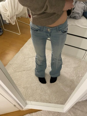 Ljusblå bootcut jeans med broderi - Säljer ett par ljusblå bootcut jeans från Nelly. Dem är i storlek 36/short. Jag säljer pga för stor storlek i midian och att dem alldrig används. Inge defekter.
