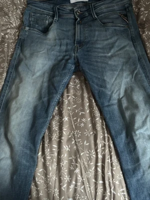 Replay ljusblå jeans herr 32/32 - Snygga ljusblå jeans från Replay i klassisk femficksmodell. Jeansen har en något tvättad look och raka ben. Tillverkade i bomull med en skön passform som passar till det mesta. Perfekta för dig som gillar stilrena och bekväma jeans.