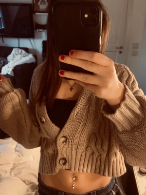 Beige/brun croppad stickad kofta - En croppad stickad kofta från NA-KD i storlek Xs.