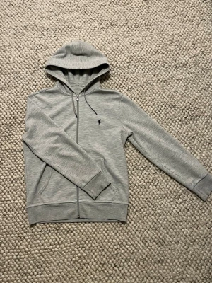 Ralph Lauren hoodie  - Säljer en Ralph Lauren hoodie i storlek S. Tröjans skick är 8,5/10 då storlekstrycket är börjat försvinna (pga torktumlare). Hör av dig om du har någon fråga. 