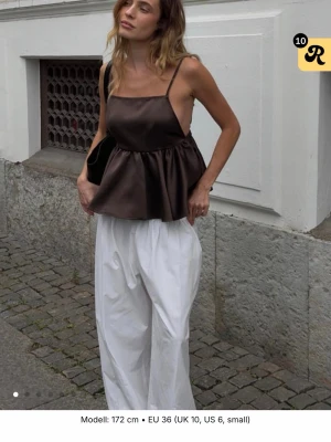 Brun peplum linnetopp med smala axelband - Säljer en brun peplum linnetopp från Nakd, aldrig använd. Så i nyskick.