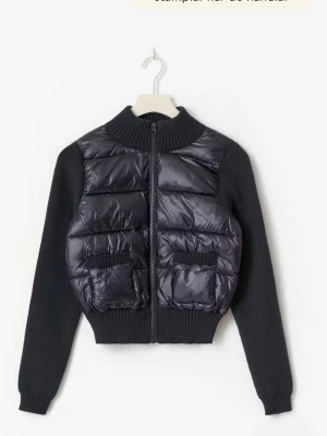 Svart dunväst med dragkedja - Snygg svart dunväst med quiltad framsida och två stora fickor. Västen har hög ribbad krage och dragkedja framtill. Perfekt för lager-på-lager och ger en cool look till din outfit.