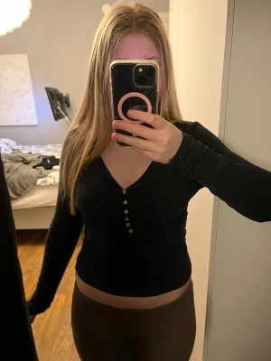 Svart långärmad topp med knappar - Svart v ringad tröja från hm med knappar. Knappt använd.