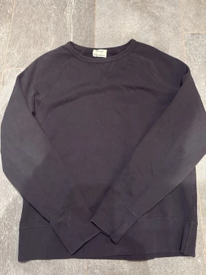 Svart sweatshirt från Acne Studios - En stilren svart sweatshirt från Acne Studios i mjuk bomull. Klassisk rund halsringning, ribbade muddar och långärmad modell. Perfekt till jeans eller kjol för en clean och enkel look.