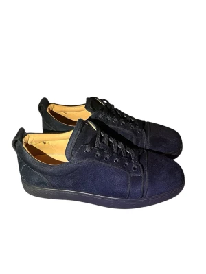 Mörkblå loubs - Snygga mörkblå loubs sneakers i mocka med klassisk röd sula och rund tå. Skorna har snörning och en stilren design som passar perfekt till jeans eller chinos. Insidan är ljusbeige och sulan har Louboutins signaturmönster.