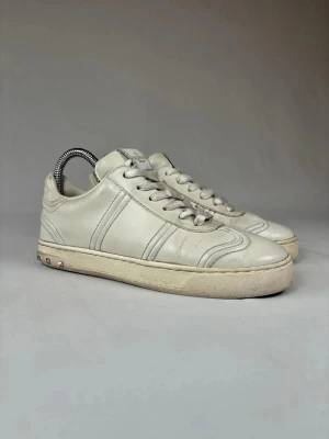 Valentino vita sneakers - (Nypris 6500kr)Snygga äkta vita sneakers från Valentino med klassisk låg profil och coola silverfärgade nitar på hälen. Skorna är i skinn och har rund tå, snörning och diskreta sömdetaljer. Perfekta för dig som vill ha en clean look.(Size 37 men passar även 37,5