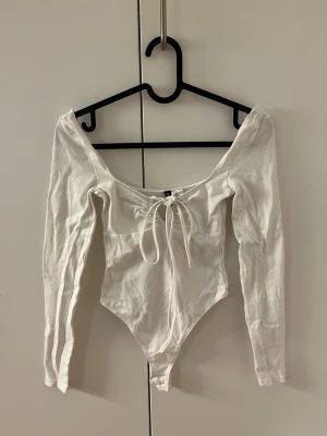 Vit Body - Snygg vit body från h&m i storlek xss, aldrig använd❣️( endast skrynklig på bilderna då den legat vikt väldigt länge ) 