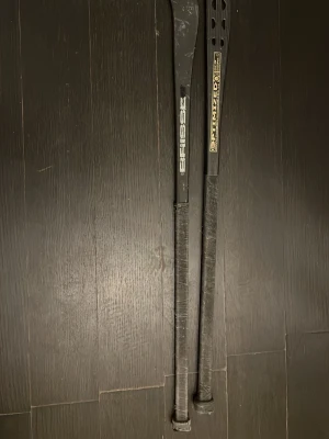 Bandy klubbor  - Bilden visar två bandy klubbor en brisse black 200kr och en optimzed nano black 250 kr 