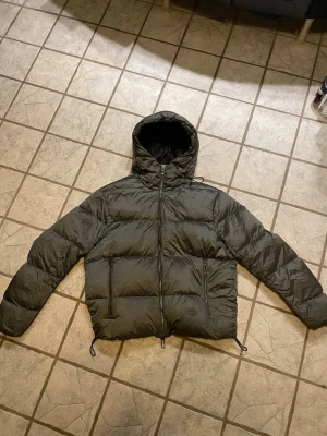 Emporio Armani Down Bomber, storlek 50 (M) - Säljer en original Emporio Armani dunjacka i mycket bra skick.  • storlek 50 (M) • Lätt men mycket varm (äkta dun) • Silvergrå färg • Vind- & vattenavvisande • Huva och dragkedjefickor • Stilren och exklusiv  Nypris ca 6 500kr