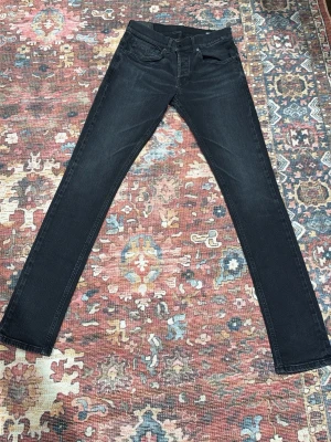 Svarta skinny jeans från Dondup - Säljer ett par svarta skinny jeans från Dondup. Jeansen har klassisk femficksdesign, smal passform och är tillverkade i ett mjukt jeansmaterial. Snyggt minimalistiska utan synliga loggor på benen och med diskreta sömmar. Perfekta till sneakers eller boots.