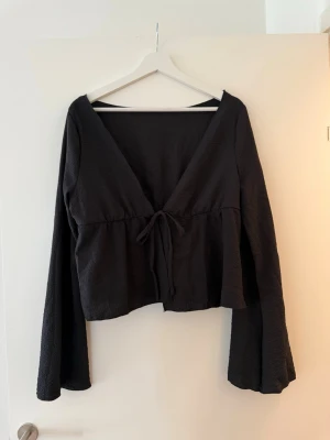 En fin svart blus  - Säljer en fin svart blus, till finare tillfällen eller en sommardag. Känns som storlek S-M