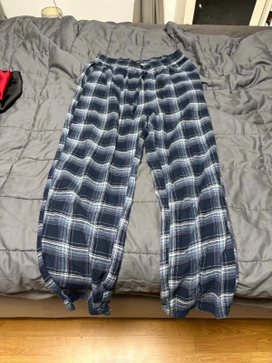 Blå-rutig byxa från Maunderwear - Säljer ett par blå-rutiga byxor från Maunderwear i mjukt tyg. Byxorna har resår i midjan och snörning, storlek S/M