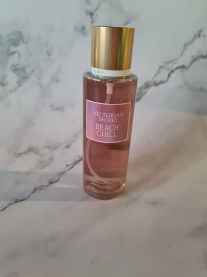 Victoria's Secret Beach Chill mist - Fräsch body mist med toner av päron, liljekonvalj och glittrande vatten. Perfekt för dig som vill ha en lätt och uppfriskande doft. Volym: 250 ml. Ingredienser: vatten, alkohol denat., glycerin, parfym, ricinolja m.fl. Helt ny och oanvänd men klistret på baksidan har släppt lite se bilderna