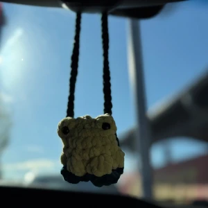 Virkat bilhänge - En virkad groda som passar perfekt att hänga i bilen men självfallet även på andra ställen. Hänget är virkad i ljusgrönt och brunt fluffigt garn vilket gör den väldigt mysig 🐸Gosedjuren lämpar sig inte för små barn då ögonen är känsliga och kan falla av om man ej är försiktig.