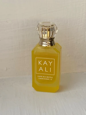 Kayali Lemon Sugar Parfym - Kayali Capri In A Bottle Lemon Sugar | 14 är en trendig parfym med en färgstark look. Perfekt för dig som gillar söta, vaniljiga och citrusaktiga dofter. Snygg flaska som sticker ut i samlingen. Flaskan är full 🩷 30ml