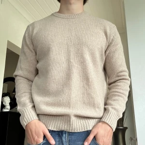 Stickad tröja från Benetton - Säljer en schysst beige stickad tröja från Benetton | Storlek Medium | Modellen på bilden är 178cm | Hör av dig vid minsta fundering