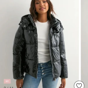 Svart glansig pufferjacka med huva - Säljer en svart, glansig pufferjacka med huva och dragkedja framtill. Jätte stilig och framförallt varm till vintern. Köp förra året och nu är för liten😢 ordinarie pris 799kr men säljer för 550 ( kontakta om frågor eller pris ) 