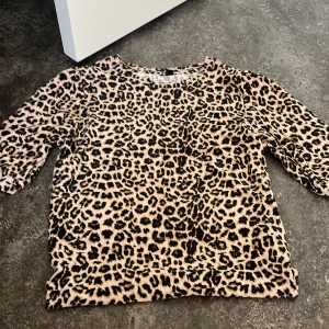 Leopardmönstrad topp XS - Säljer en snygg topp i leopardmönster med beige och svarta toner. Modellen har trekvartsärm och är i ett mjukt, stretchigt material som känns skönt mot huden. Perfekt för dig som vill sticka ut lite extra med din outfit. Lite stor i storlek💕