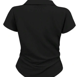 Svart piké t-shirt från Polo Ralph Lauren - Svart piké t-shirt från Polo Ralph Lauren med klassisk krage och vit broderad logga på bröstet. Modellen är figurnära med korta ärmar och v-ringad hals. Perfekt för en clean och sportig look.