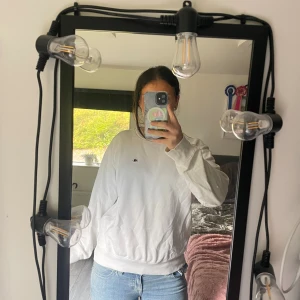 Vit sweatshirt från Champion - Säljer en klassisk vit sweatshirt från Champion med liten broderad logga på bröstet. Tröjan har rund halsringning och långa ärmar, perfekt för en chill och avslappnad stil. Passar lika bra till jeans som till mjukisbyxor.