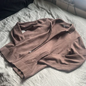 Cardigan brun - Säljer denna bruna stickade kofta från med hel dragkedja, perfekt nu till hösten Tröjan har ribbade muddar vid ärmslut, nederkant och krage. Storlek: M|  Skick: 9/10 använd ett få tal gånger. Vid minsta fråga eller fundering är det bara att höra av sig🫡🤗