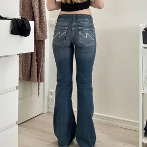 Nelly jeans - ”Stich jeans” från Nelly, Blå bootcut jeans med låg midja och snygga broderade detaljer på bakfickorna. Stretchig och bekväm passform😁💗ps är 170cm