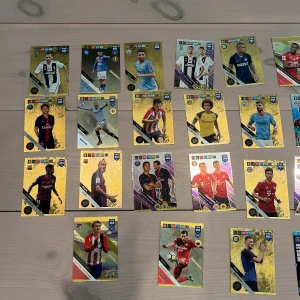 FIFA 365 Fotbollskort - Samling av FIFA 365 fotbollskort med kända spelare och lag från hela världen. Perfekt för dig som älskar fotboll, vill byta med vänner eller bygga din egen drömsamling. Färgglada och glittriga kort som gör samlandet extra kul! Korten som ligger på golvet är lite mer speciella kort bland annat limited edition som många är. De korten som ligger i högen är lite mer vanliga kort. Jag kan sälja kort separat men säljer gärna alla tillsammans. 