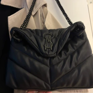 Steve madden väska - Steve madden väska, köpt på Zalando för 1300. Den är i bra skick men färgen har lossnat lite på kedjan och bokstäverna där bak som man ser på bilderna men de är ingenting man märker.