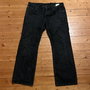 Svarta jeans från Mc Gordon W34 L30 - Svarta jeans från Mc Gordon i klassisk rak modell. Jeansen är tillverkade i 100% bomull och har fem fickor samt bälteshällor. Snygg, enkel look som passar till det mesta. Färg: svart. Nyskick bortsett från en liten fläck på baksidan av byxbenet.