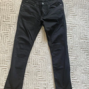Svarta jeans från Acne Studios - Svarta jeans från Acne Studios med klassisk femficksdesign, slim fit. Byxorna har bälteshällor och knappstängning framtill. Snygg och stilren modell som passar till allt! Vid fler frågor eller funderingar tveka inte på att skriva
