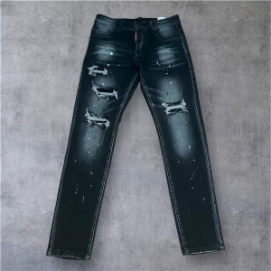 Svarta Dsquared2 jeans  - Storlek 29 men passar båda 30 och 28.Snygga svarta jeans från Dsquared2 med slitna detaljer och färgstänk framtill. På bakfickan finns broderade vita blommor och blå brodyr. Jeansen har rak passform och cool streetkänsla, perfekta för dig som vill sticka ut.
